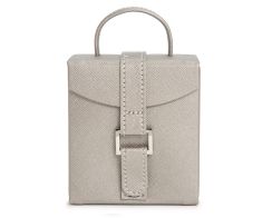 Compact fold-out jewelry box in pewter plant-based materials, shown closed with an upright top carry handle and a secure vertical strap closure with a silver metal bar accent.