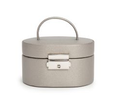 Closed front view of the compact Heritage Mini Oval Jewelry Box showcasing its textured pewter plant-based materials exterior, integrated top handle, and polished silver push-lock closure.