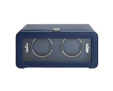 Windsor Double Watch Winder shown from a straight front view, featuring a closed wide rectangular door with a long glass viewing window framed in textured navy blue material, revealing two side-by-side navy watch cuffs inside.